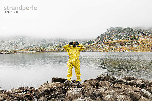 Person  die während der Covid-19-Pandemie einen gelben Schutzanzug trägt