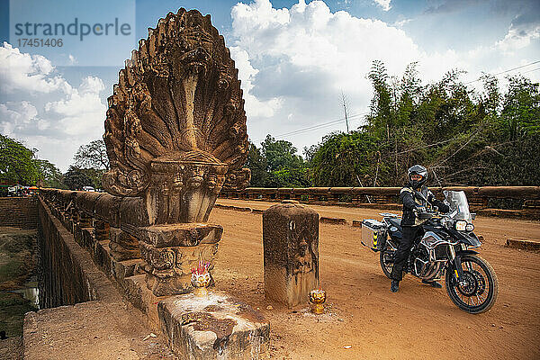 Mann fährt mit seinem Abenteuermotorrad über die Drachenbrücke in Kambodscha