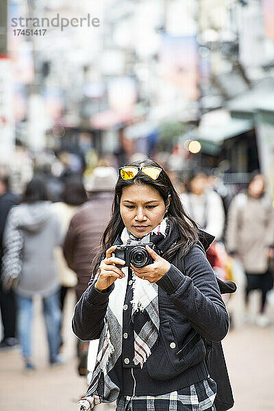 Frau macht ein Foto mit einer digitalen spiegellosen Kamera