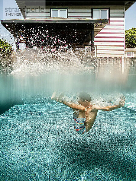 Geteilte Ansicht eines 7-jährigen Jungen  der zu Hause in einen Pool springt