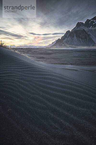 Stoksness-Berge und schwarzer Sandstrand bei Sonnenuntergang