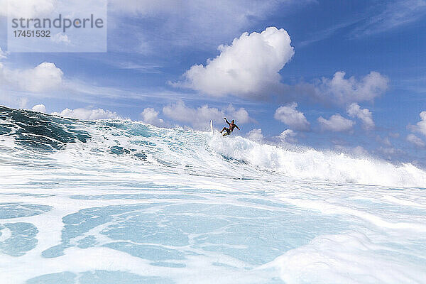 Surfer auf einer blauen Welle an einem sonnigen Tag