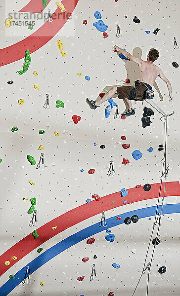 Mann klettert an der Indoor-Kletterwand in London