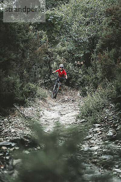 Halbnahe Aufnahme einer Mountainbikerin auf felsigem Weg