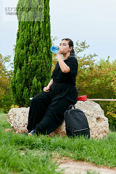 Frau trinkt Wasser nach Kung-Fu-Training in einem Park