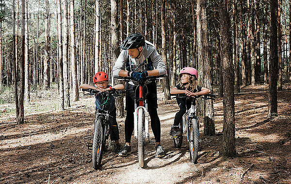 Papa und seine Kinder genießen eine Radtour im Wald