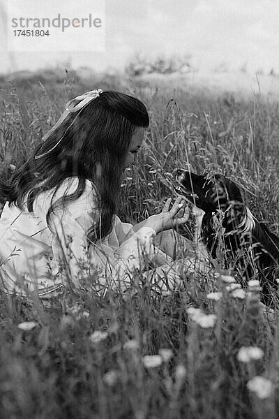 Glückliches Mädchen  das draußen seinen Hund umarmt. Lebensstile und Haustierpflegekonzept.