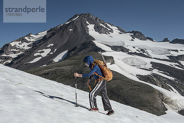 Ein Junge wandert ein Schneefeld in der Glacier Peak Wilderness hinauf
