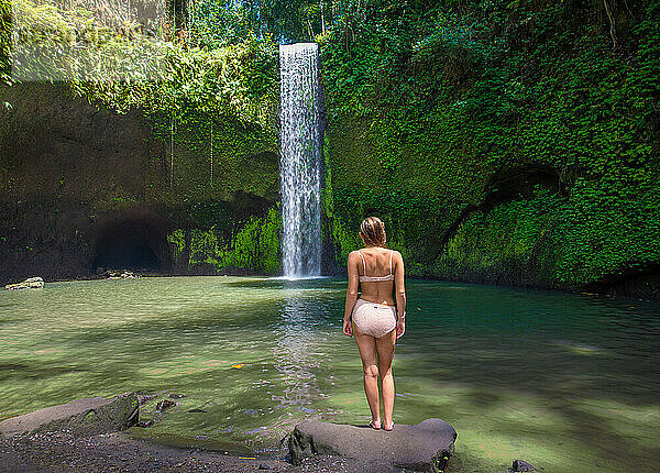 Mädchen am ruhigen Wasserfall in Bali  Indonesien