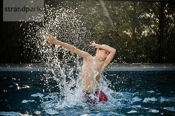Glücklicher 8-jähriger Junge  der sich im Sommer im Schwimmbad vergnügt