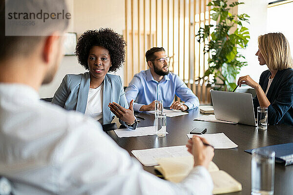 Gemischtrassige Kollegen diskutieren gemeinsam über das Projekt