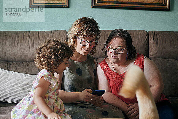 Mutter mit ihrer Tochter und ihrer Schwester mit Down-Syndrom zu Hause
