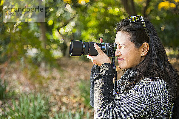 Frau macht ein Foto mit einer digitalen spiegellosen Kamera