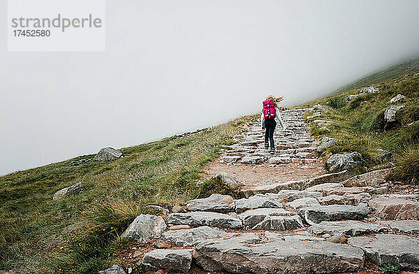 Kind wandert glücklich die Bergkette Ben Nevis hinauf