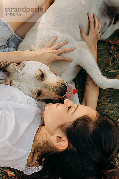 Frau umarmt ihren Labrador. Lebensstile und Haustierpflegekonzept.