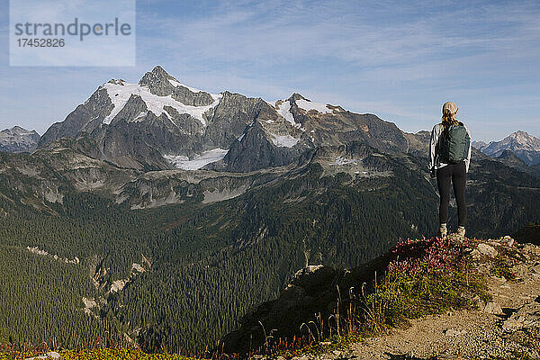 Wanderin steht über einem Tal mit dem Berg Shuksan