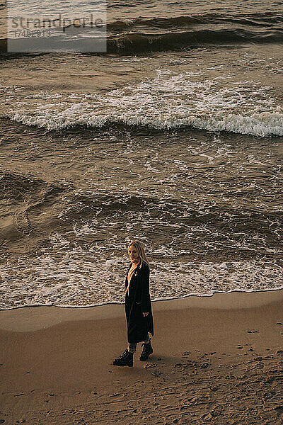 Eine junge Frau spaziert an der Ostseeküste entlang