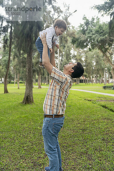 Vater zieht ihr Kind groß  während sie draußen glücklich lachen