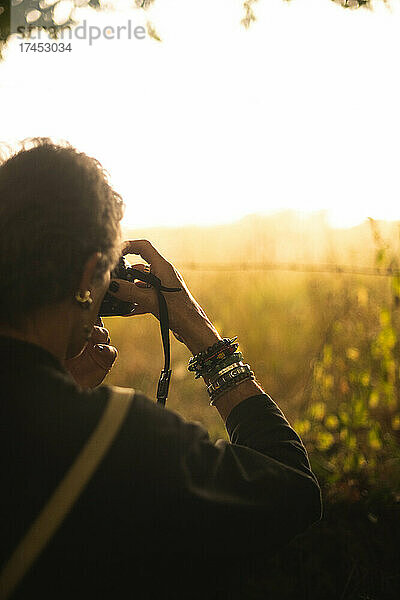 Eine Frau fotografiert einen Sonnenuntergang