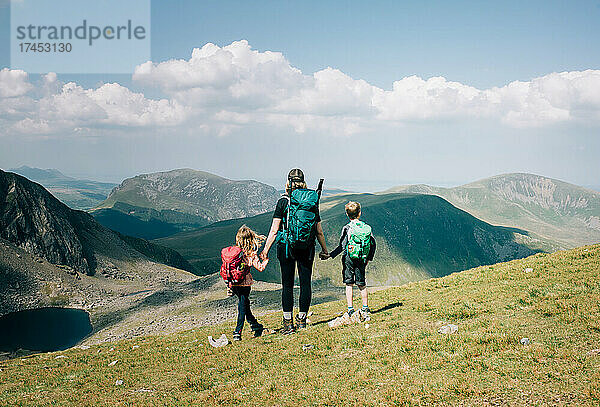 Mutter nimmt sich mit ihren Kindern einen Moment Zeit  um die Aussicht auf Mount Snowdon zu genießen
