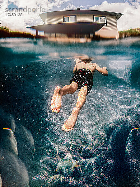 8 Jahre alter Junge schwimmt im Sommer auf sein Haus zu