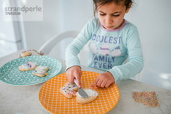 Junges Mädchen dekoriert Ostereierplätzchen