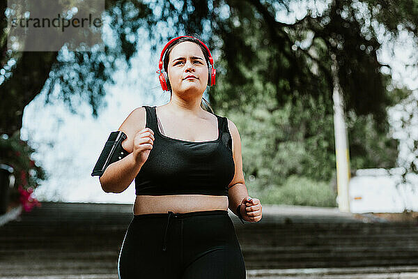 Übergroße junge lateinamerikanische Frau läuft im Park in Mexiko