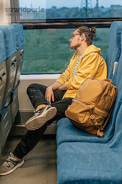 Junger Teenager reist im Zug  im öffentlichen Nahverkehr.