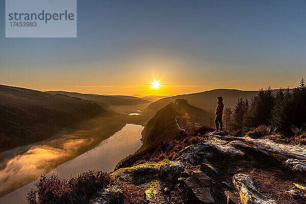 Ein Mann steht auf dem Spink-Aussichtspunkt und bewundert den Sonnenaufgang