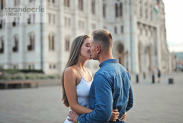 Junges Paar küsst sich im Hintergrund des Parlaments in b