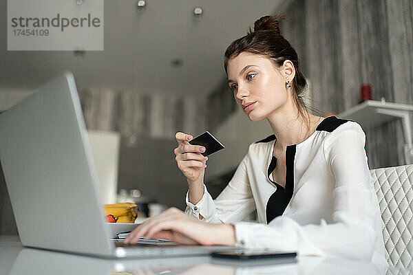 Frau mit Kreditkarte und Laptop