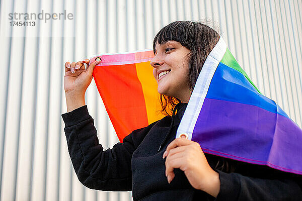 Porträt einer Latina-Frau  die die Regenbogenfahne trägt