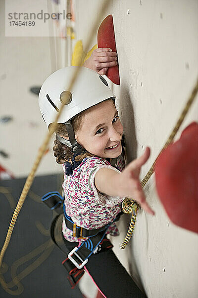 Mädchen klettert an der Indoor-Kletterwand in London