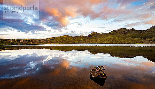 Spiegelung des Himmels bei Sonnenuntergang im Mirror Lake Schottland mit Heidehügeln