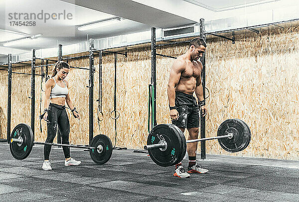 Ein paar Männer und Frauen machen Gewichte im Fitnessstudio  Crossfit