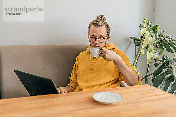 Teenager junger Mann trinkt Kaffee im Café.