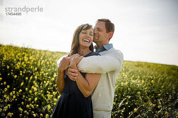 Mann und Frau lachen im Wildblumenfeld in San Diego