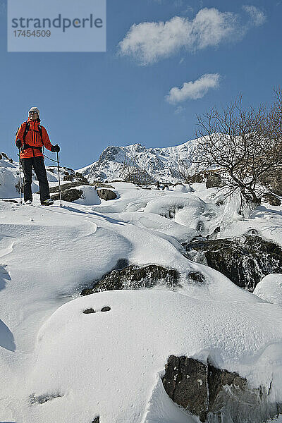 Frau steigt durch Schnee und Eis vom Berg Tryfan ab