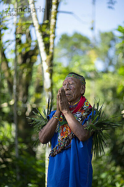 Cofan-indigener Schamane betet mit vereinten Händen im Amazonas-Regenwald