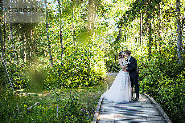 Junges romantisches Paar küsst sich im Wald.