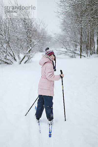 Das Mädchen fährt im Schnee Ski.