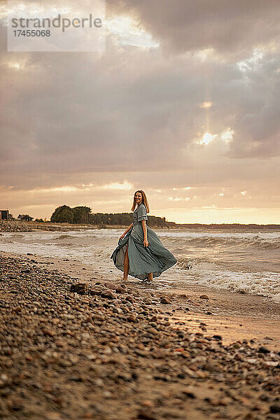 Junge Frau geht am Ufer entlang