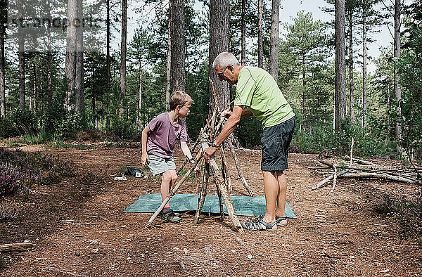 Großvater hilft Enkel beim Aufbau eines Lagers im Wald