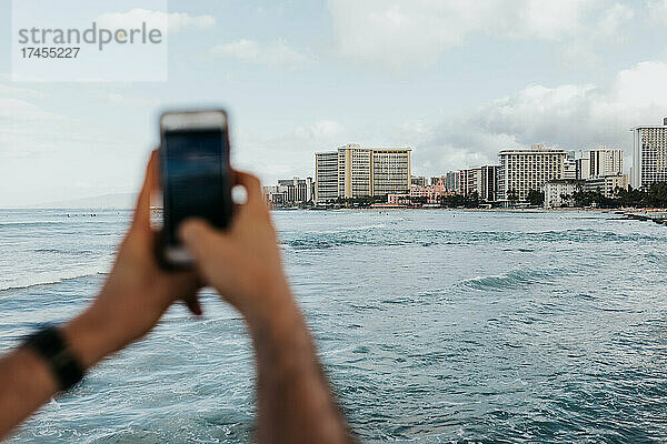 Erwachsener Mann fotografiert das Viertel und die Küste von Waikiki