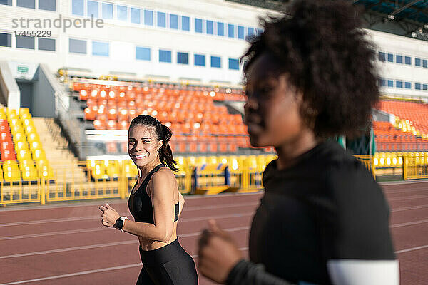 Diverse sportswomen running on track
