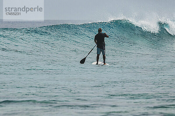 Asiatischer Mann auf Stand-Up-Paddling-Board