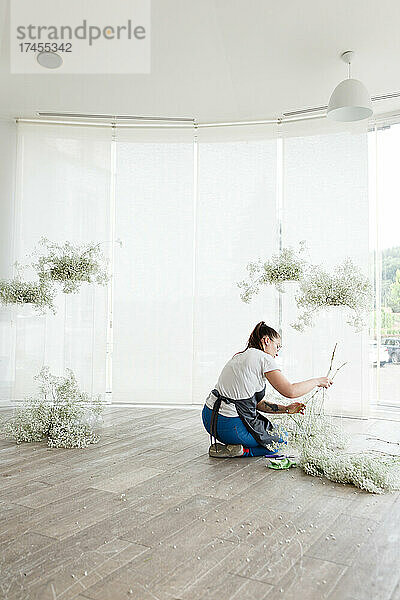 Eine Floristin und Dekorateurin schmückt den Hochzeitsinnenraum mit Blumen