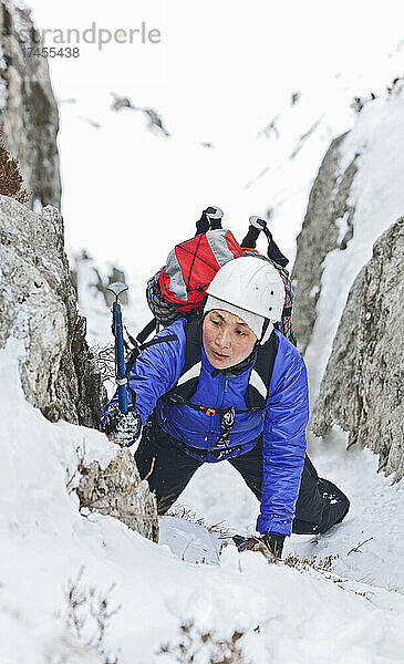 Frau klettert im Winter in Nordwales auf den Mount Tryfan