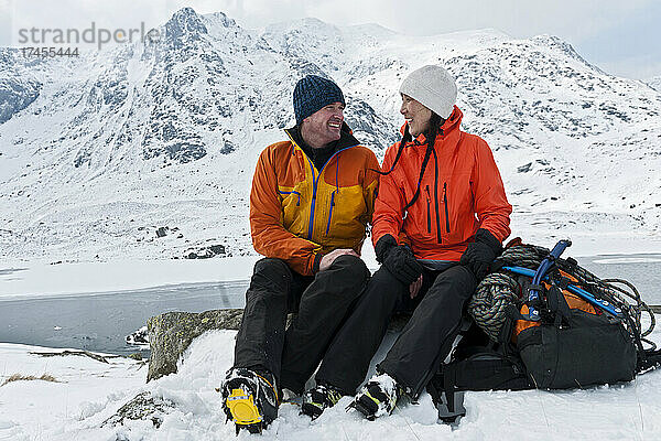 Paar ruht sich auf einer Winterwanderung in Tryfan im Norden von Wales aus