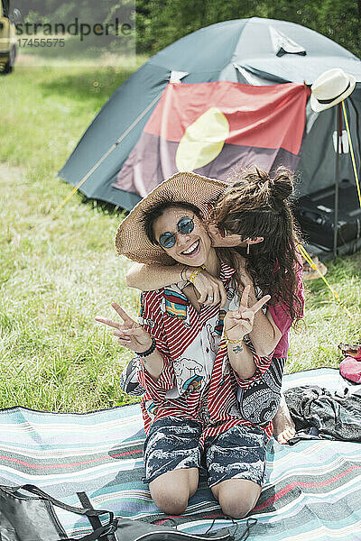 Buntes queeres weibliches Paar umarmt sich vor dem Zelt im Sommercamp